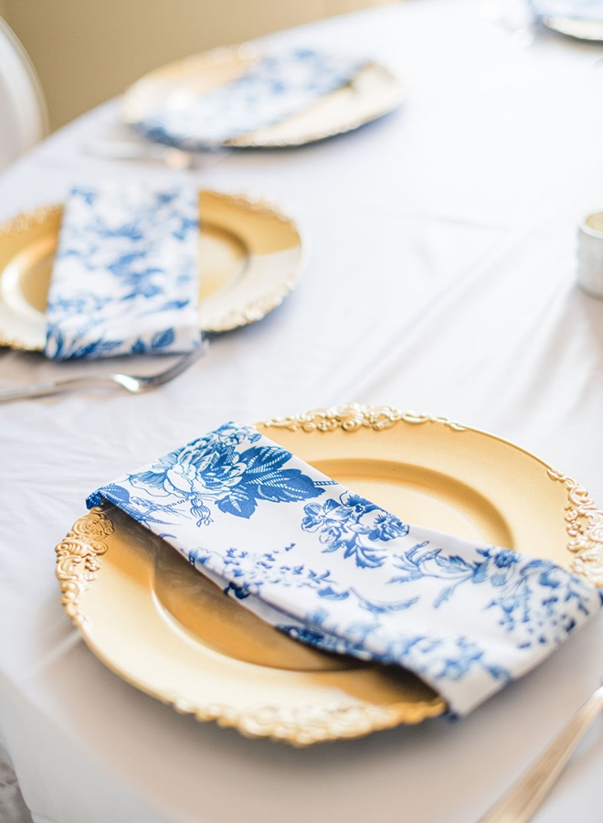 Blue floral decor linens detail the wedding reception tables.