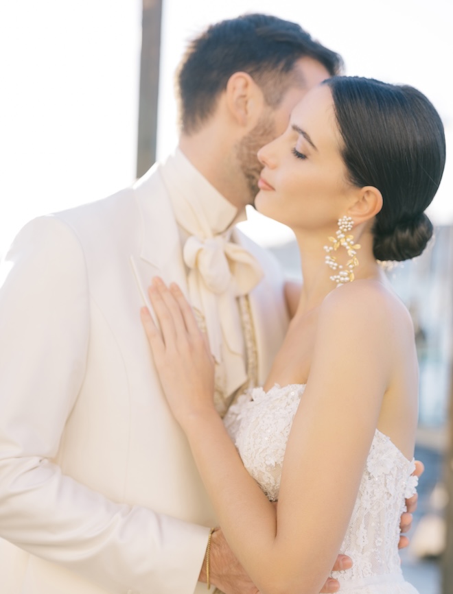 The bride resting her hand on the grooms chest outside the canal.