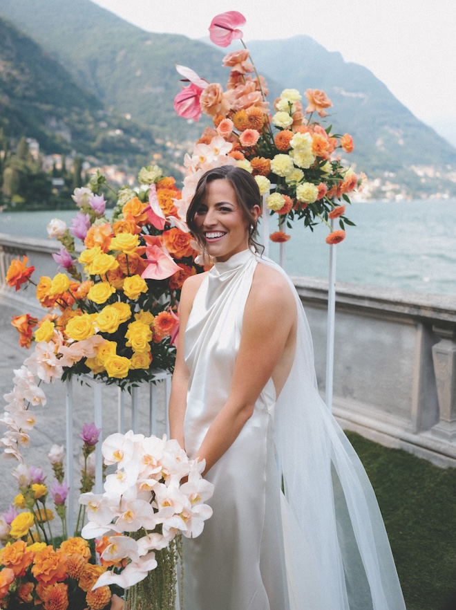 The bride holding a bouquet of orchids in front of the altar florals.