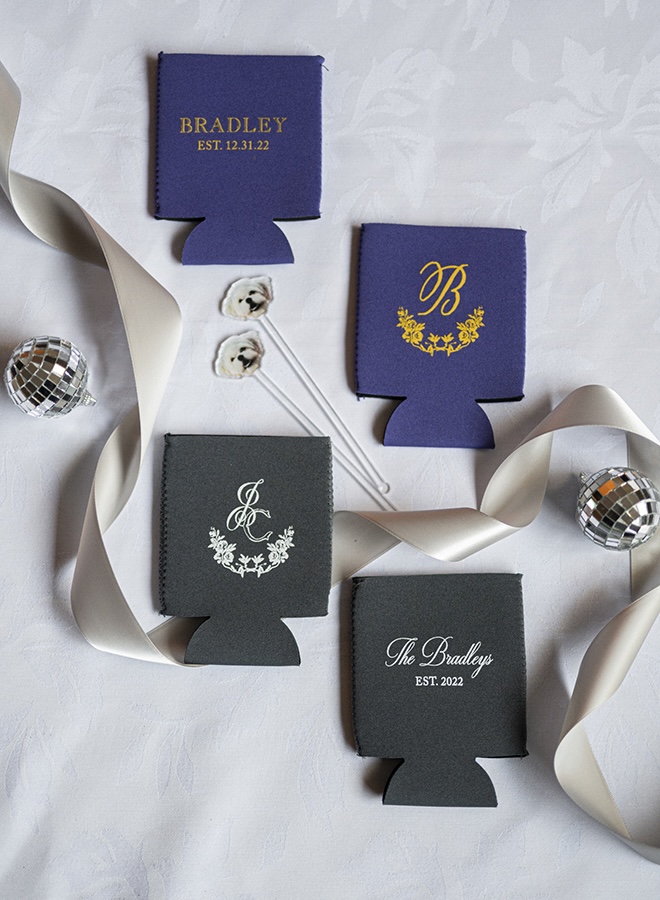The bride and groom hand out custom koozies with their initials for their wedding guests.