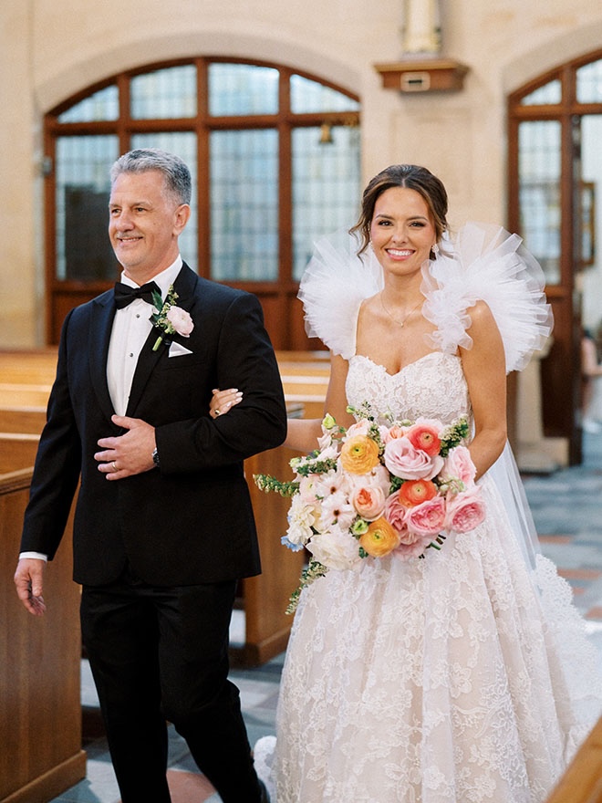 The bride and her father walk down the aisle at the traditional church ceremony in Houston.