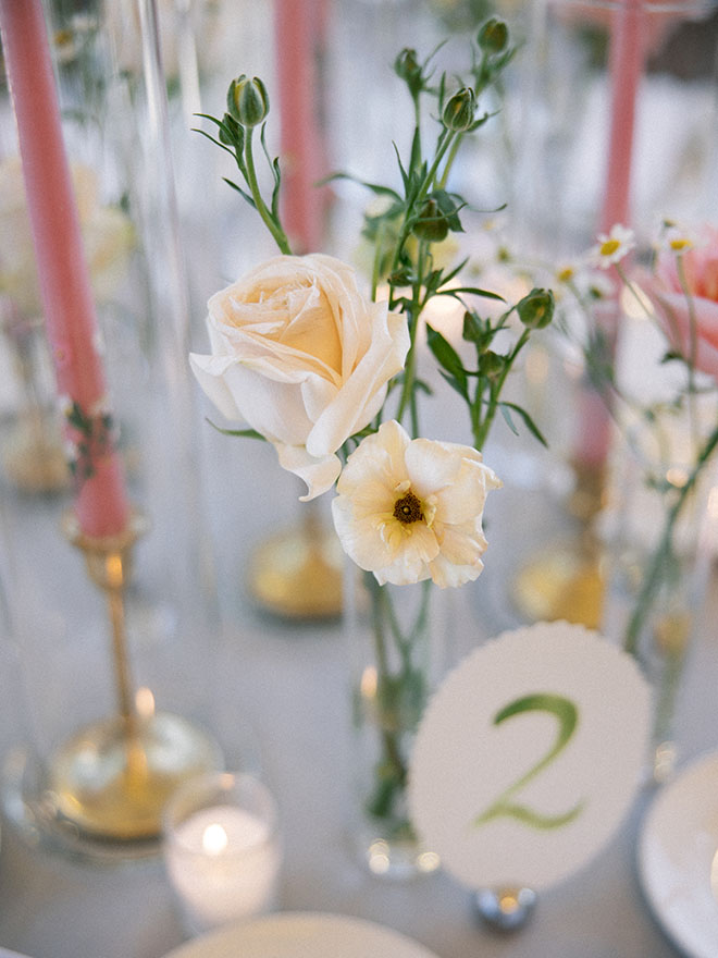 Hand painted tables numbers, pink candles and bud vases decorate the reception tables. 