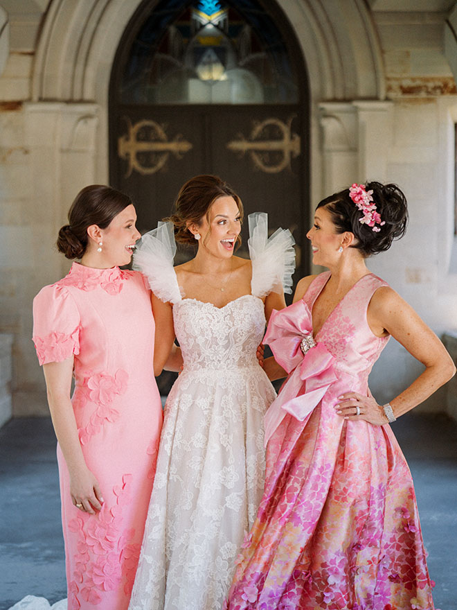 The bride with her mother and sister smile outside a Houston church. 