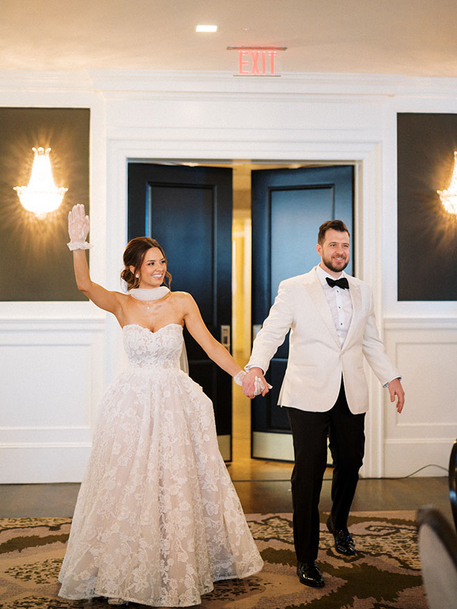 The couple hold hands as they walk into their wedding reception in downtown Houston.