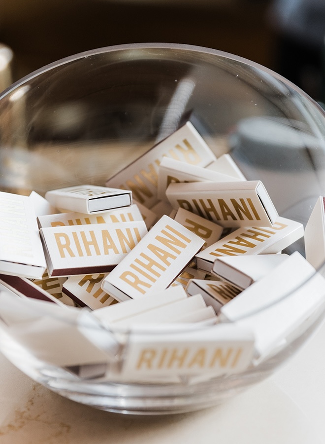 Personalized wedding favors with the couples last name are in a glass bowl for guests.