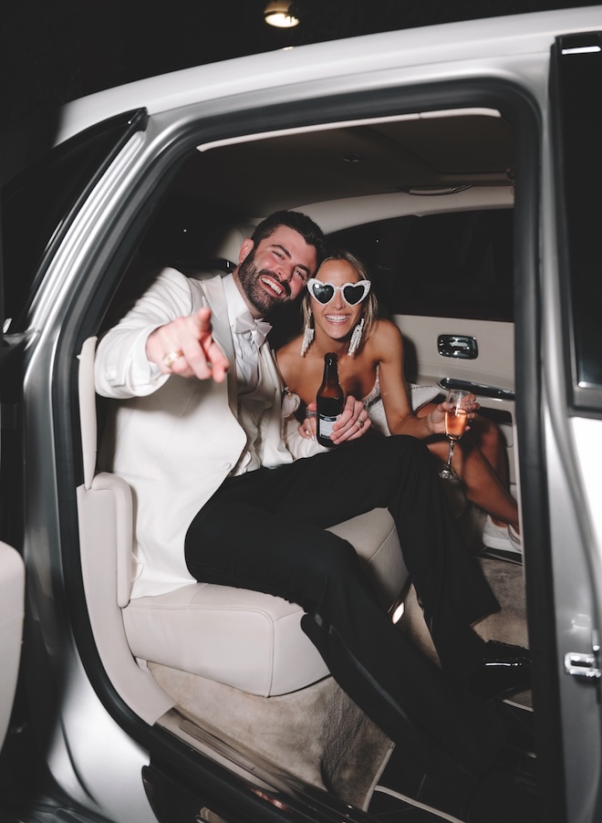 The bride and groom ride off on their wedding day luxury getaway car in Houston. 