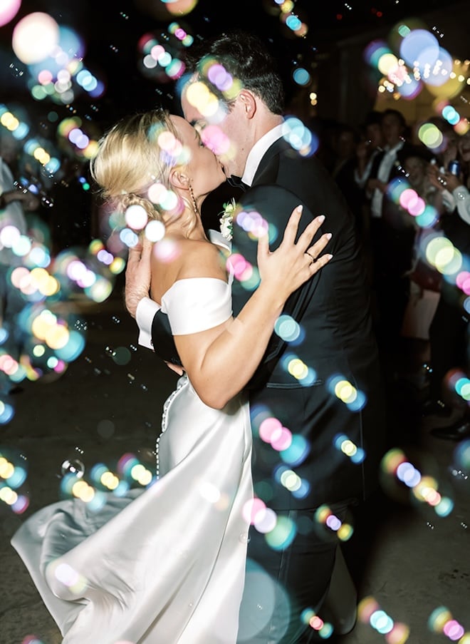 The couple share a kiss during their bubble send-off from their Houston Zoo wedding. 