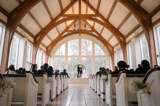 The bride and groom hold hands on the alter during their wedding ceremony. 