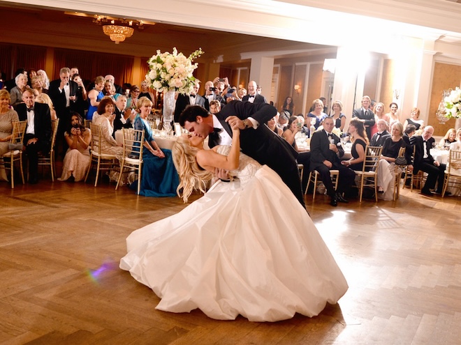The groom dips the bride and gives her a kiss on t