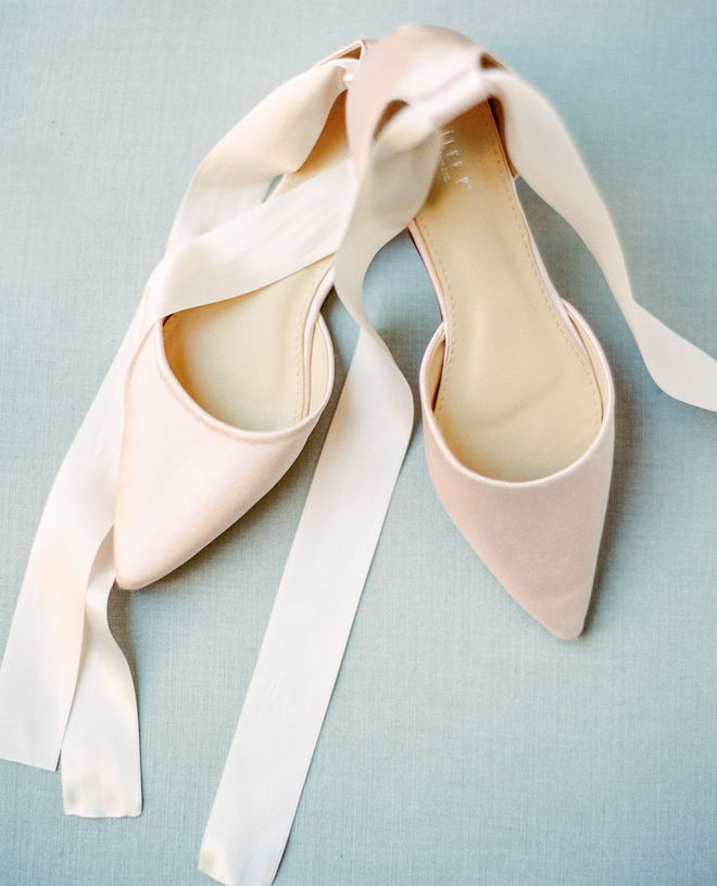 The bride wears light pink, satin shoes for her wedding day in Houston. 