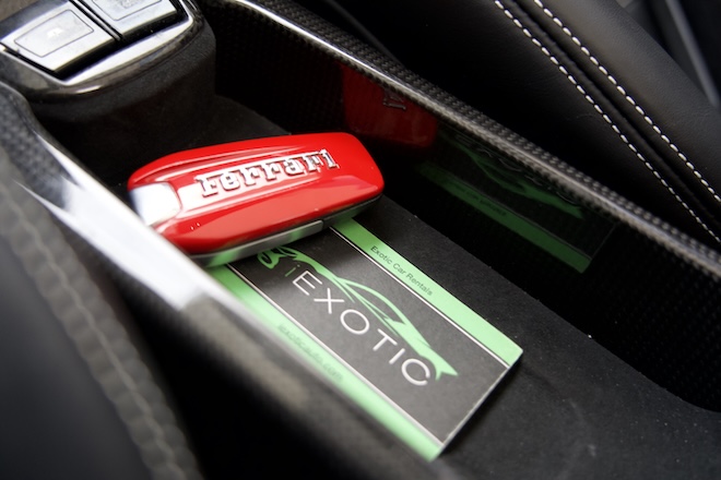 A set of red Ferarri keys sit in the console of the car. 