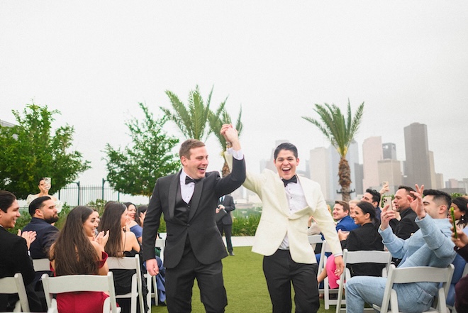 The grooms cheering as they walk back down the aisle on the Sol 7 green at Thompson Houston. 