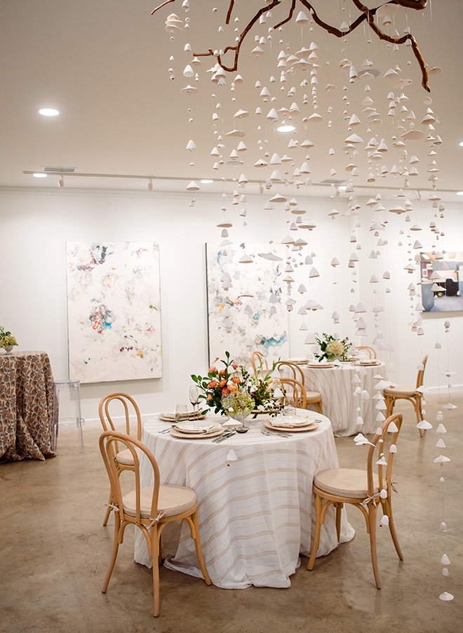 Reception tables are placed all around the art gallery. 