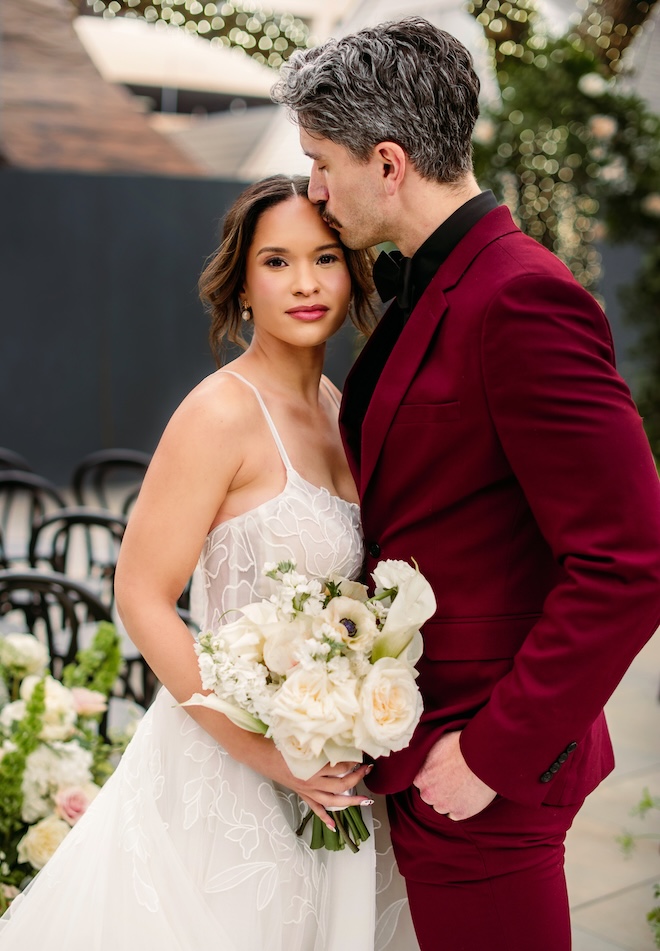 The groom kisses the bride on the forehead in the courtyard of Horizon on Sunset. 