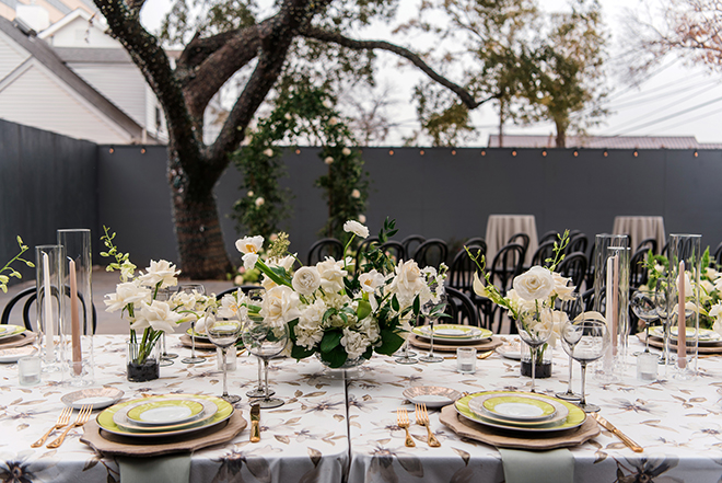 Green flatware and florals line the table at the wedding reception. 