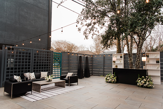 Lounge seating and cocktail bar are placed in the courtyard under string lights for cocktail hour. 