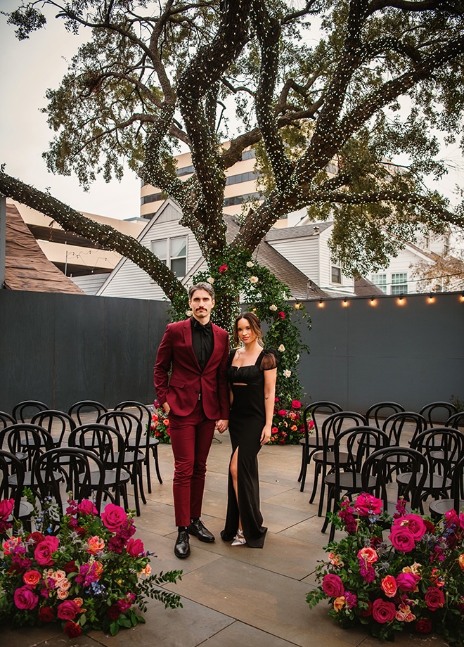 The groom wears a maroon suite and the bride wears a black gown for an outdoor ceremony at Horizon on Sunset. 