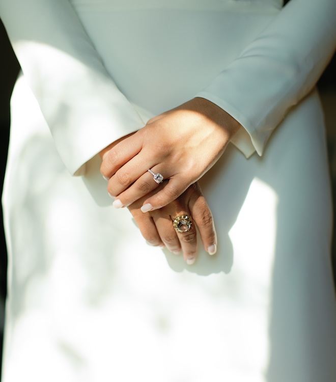 The bride holds her hands with her engagement ring and antique ring from Shaftel Diamonds. 