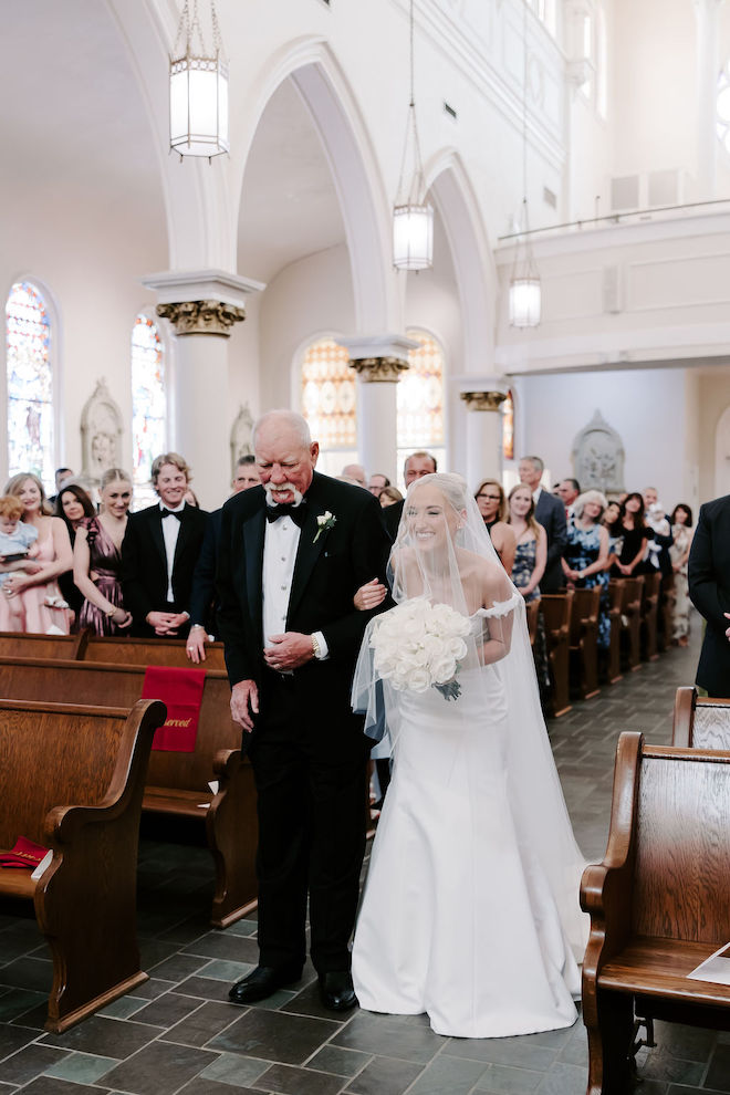 Bride and father walking down the aisle in the church. 