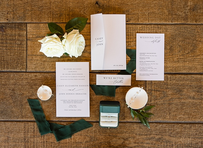 Elizabeth B Photography captures a picture of the bride and groom's white and emerald green wedding invitation and stationery. 