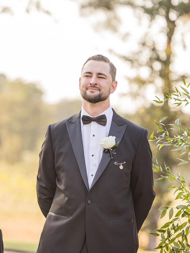The groom looks at his bride as she walks down the aisle. 