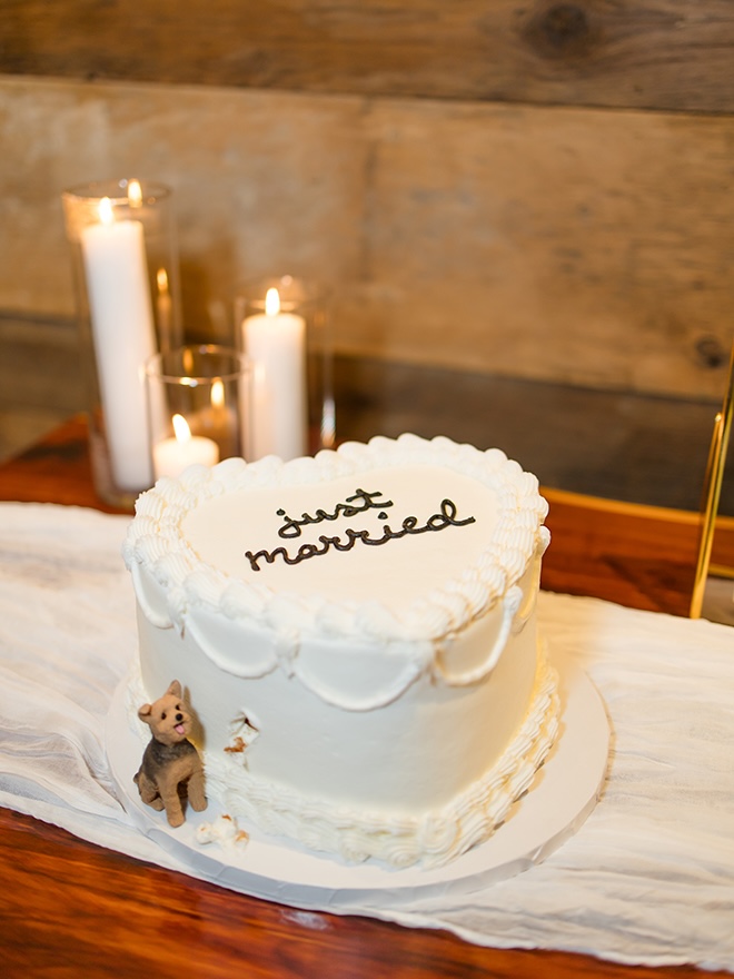 The couple's wedding cake is in the shape of a heart with a figurine of their dog.