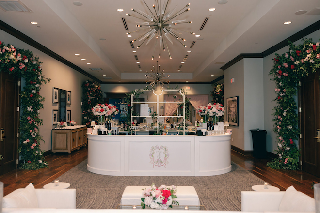 Cocktail bar inside of hotel filled with blooming pink florals.
