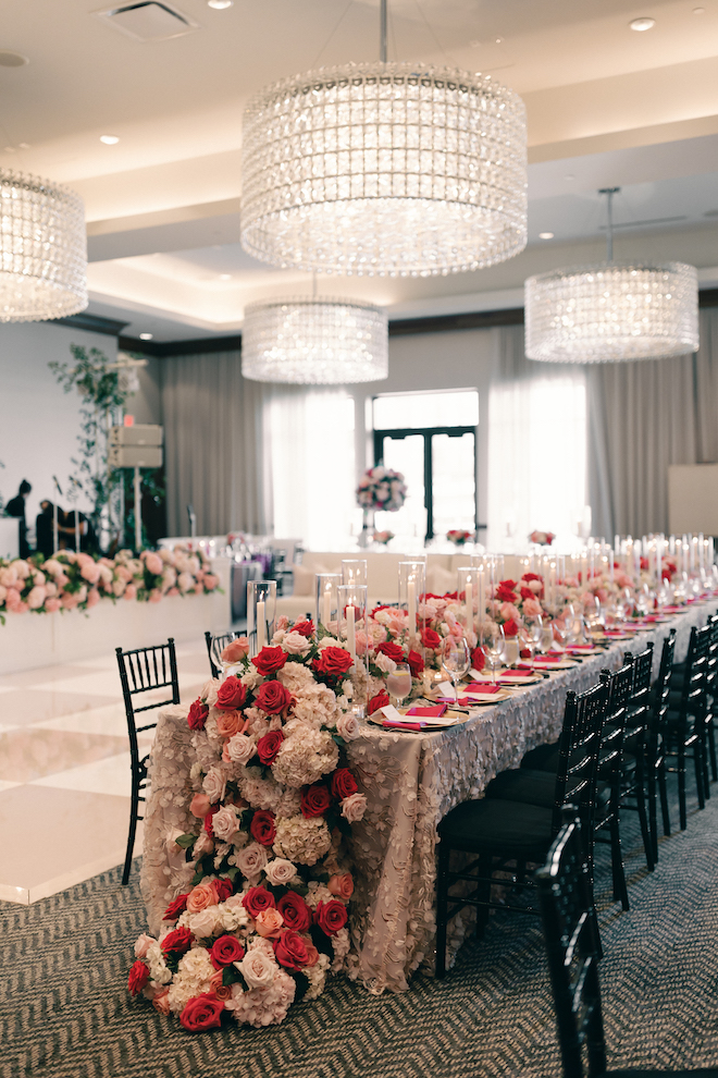 All shades of pink and white roses table runner on the long reception tables.