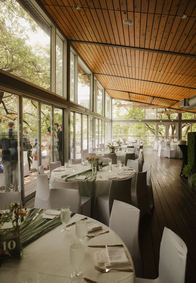 Round tables decorated with white and green decor inside The Grove. 