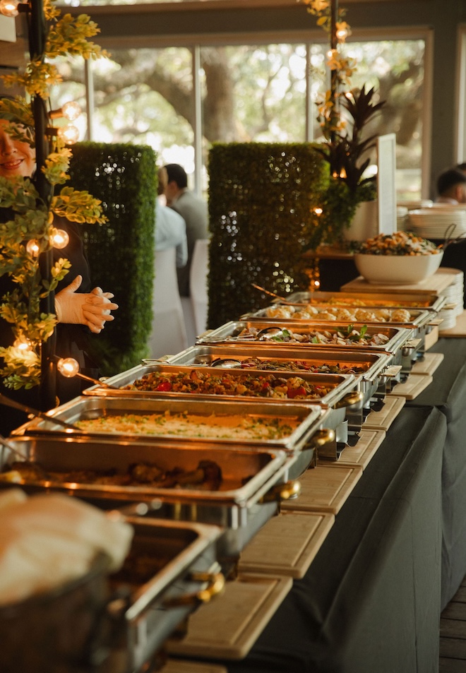 Trays of food with servers at The Grove for their New Orleans-inspired wedding brunch.