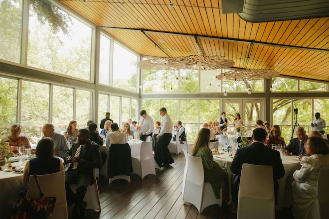 The Grove filled with wedding guests seated at round tables. 