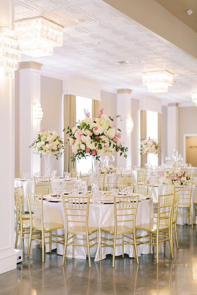 Wedding reception table with large pink and white floral bouquets as the centerpiece.