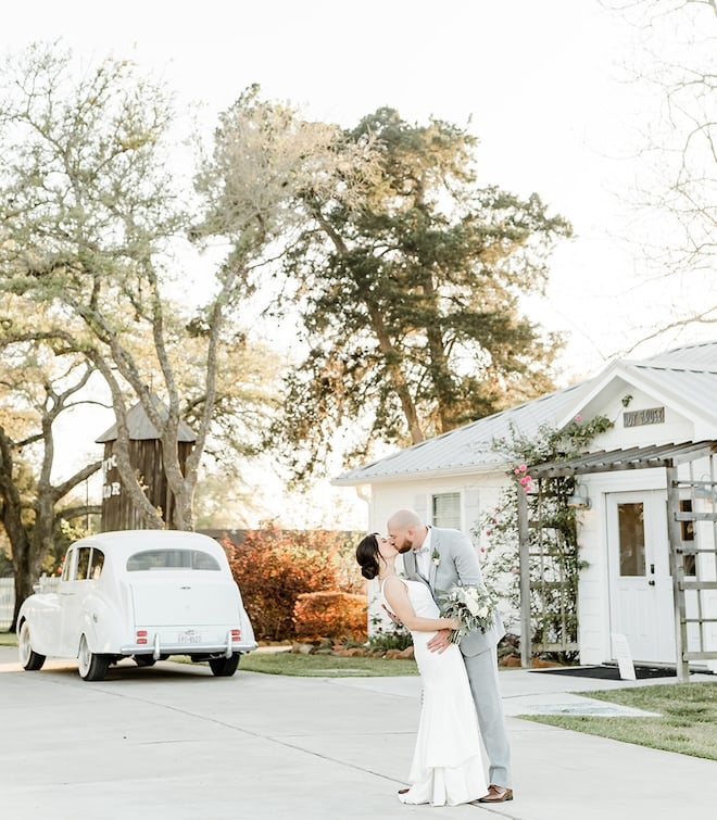 A bride ans groom kissing in front of The Pattison House in the fall.