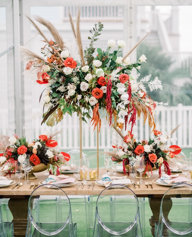 Fall-colored floral arrangements on a family-style reception table. 