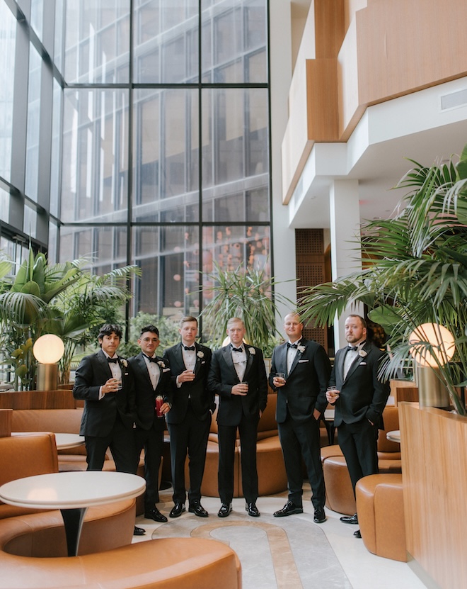 The groom and his groomsmen stand in the lobby of the C Baldwin, Curio Collection by Hilton in downtown Houston.