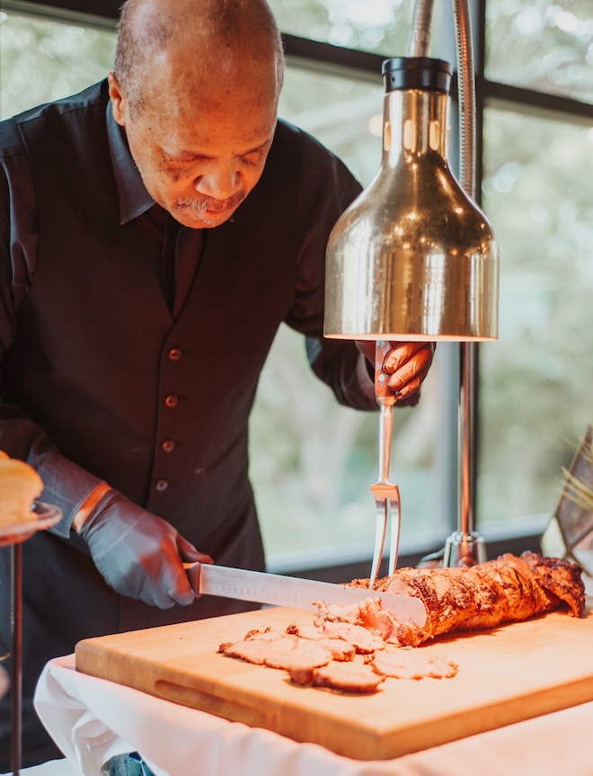 Bailey Connor Catering slices meat at a carving station. 