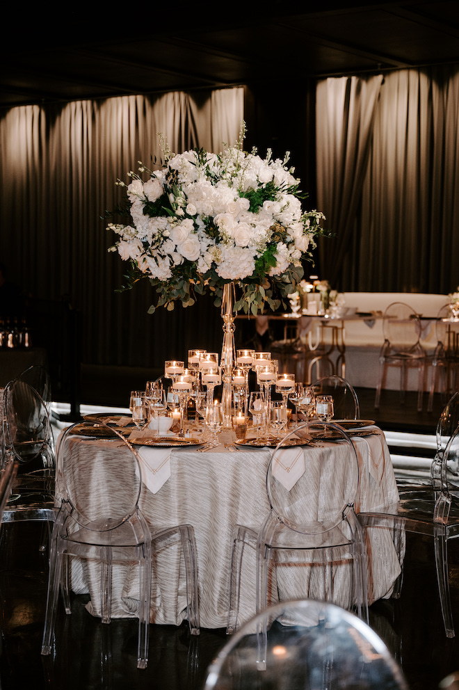 Reception table showing off big green and white floral bouquet centerpiece. 