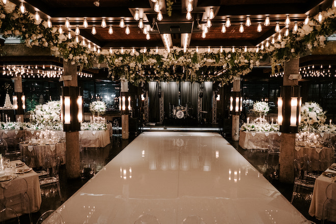 The venue in pine green and neutral colors with big floral centerpieces on the tables.