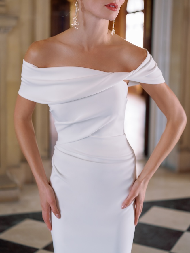 An off-the-shoulder tight wedding gown.