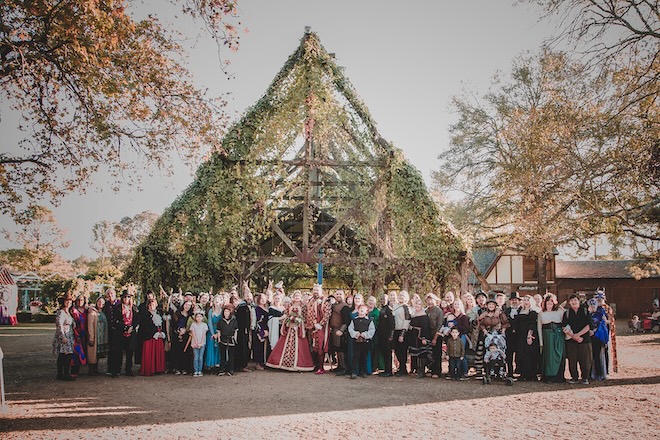 The couple and their guests posing for a photo in front of the chapel at the Texas Renaissance Festival.