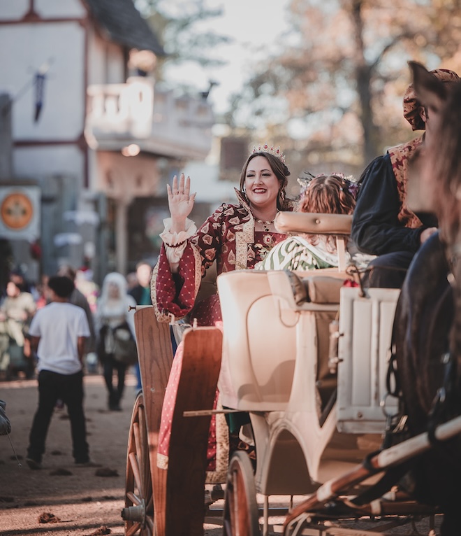 The bride waving in a horse-drawn carriage.  