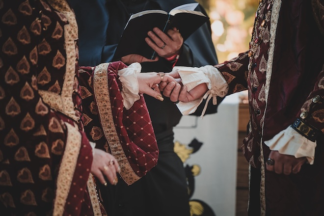 The bride and groom holding hands during their ceremony. 