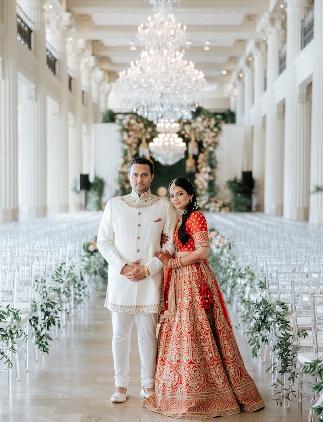 The couple stand in the middle of the aisle at their ceremony at the Corinthian Houston. 
