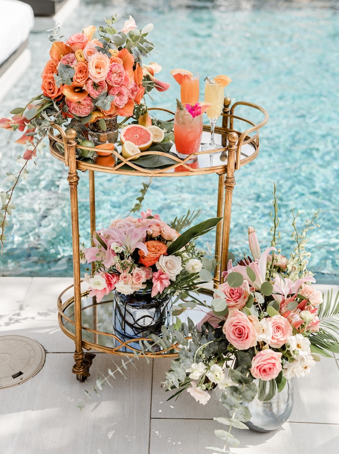 A bar cart with florals and cocktails sits next to the pool at The San Luis Resort, Spa and Conference Center.