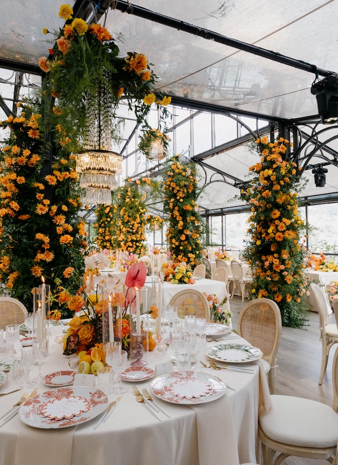 Orange flowers and greenery decorate the glass atrium. 