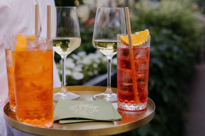 Aperol Spritz and white wine are served on a platter at a wedding in Italy.