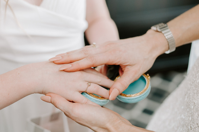 Close up of the bride and groom's daughter touching hands.