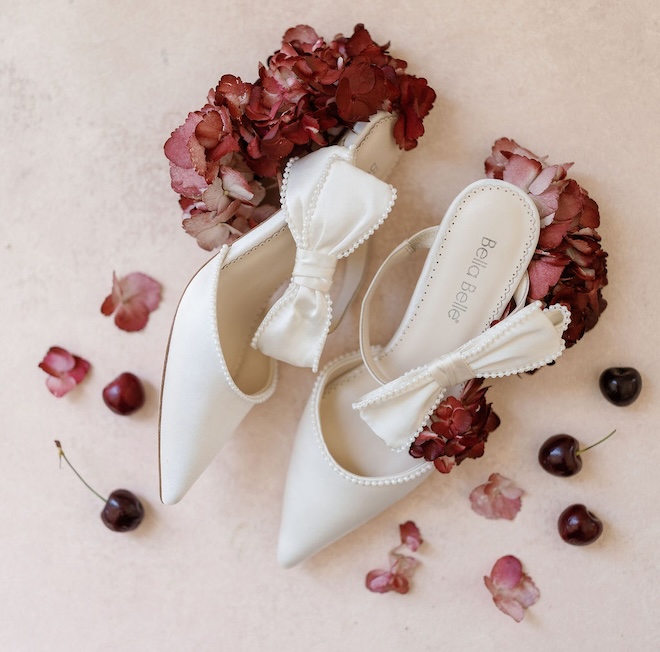 White Bella Belle shoes with red florals and cherries around them.