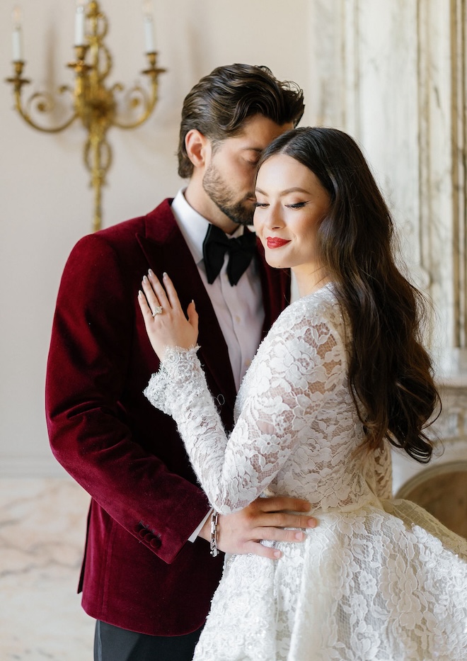 A bride and groom posing for a photo for this red wedding editorial. 