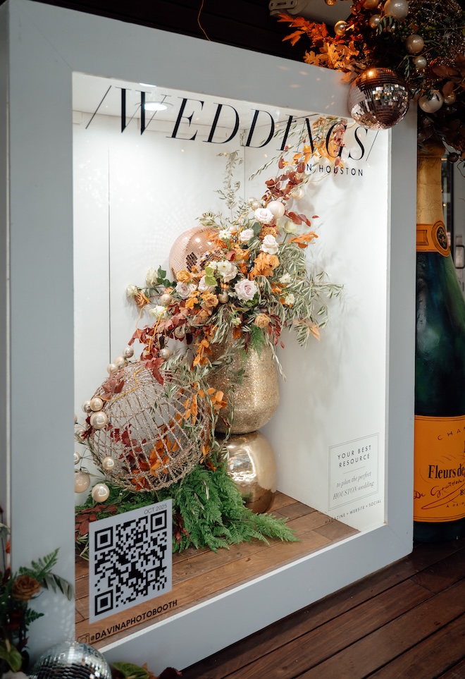 The photobooth that is a cover of Weddings in Houston magazine with florals and glittery disco balls. 